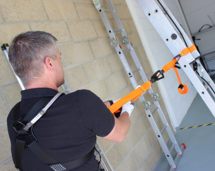 Man wearing ladder safety fall protection harness kit during height ladder safety course