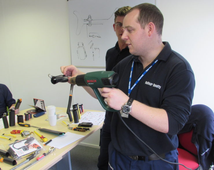 Worker practising how to tether a power drill during tool tether course