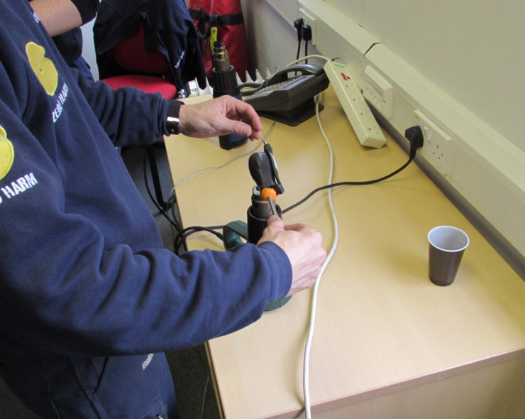 Tool tethering trainee learning to tether a power tool.