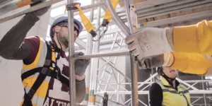 Man wearing height safety kit safely climbing a ladder